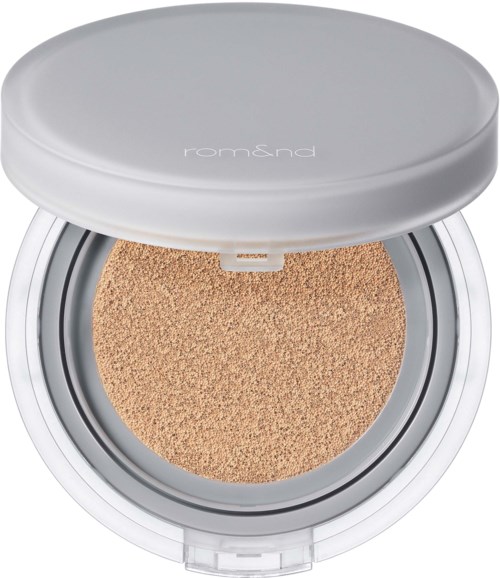En liten kompakt foundation med hvit lokk og beige svamp innvendig. Den er åpen og viser makeup-overflaten.