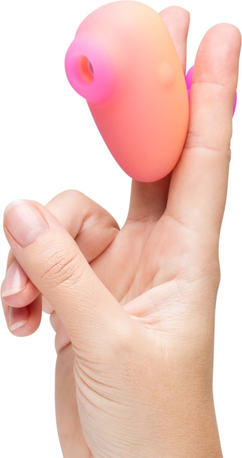 Iemand houdt een roze, zachte, schaalvormige voorwerp tussen de vingers.