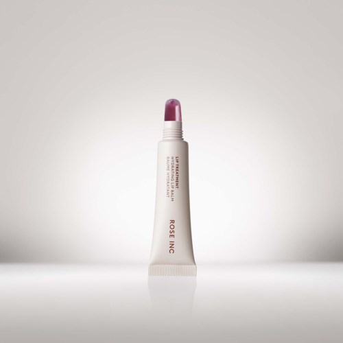 Ein Lippenbalsamtube steht senkrecht mit pinker Kappe vor hellem Hintergrund.