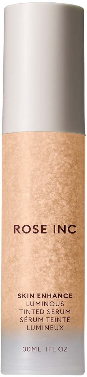 En lång, vit flaska med en rosa-beige etikett som säger 'ROSE INC' och information om ett ansiktsserum.