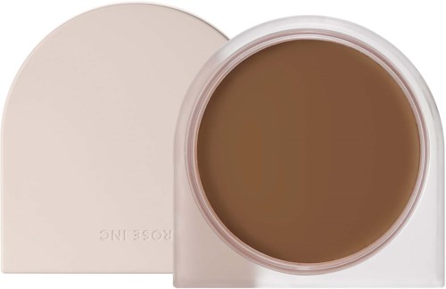 A round container with brown cosmetic product, partially covered by a square lid with rounded edges.