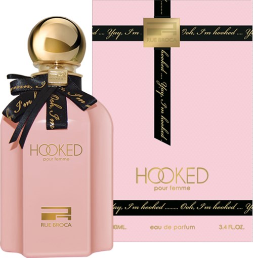 Een roze parfumfles met gouden dop en zwart lint, naast een bijpassend roze doos.