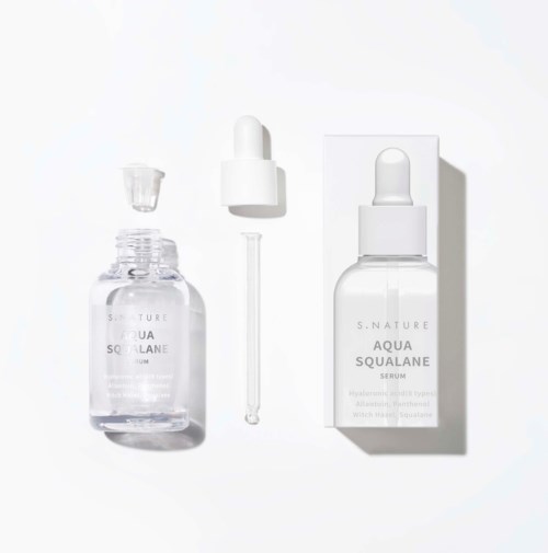 En klar flaska med en pipett bredvid en vit förpackning, båda märkta 'Aqua Squalane Serum,' på vit bakgrund.
