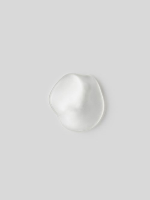 A small piece of shiny, smooth, white material on a light gray background.