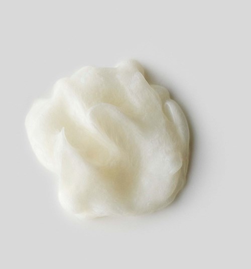 A soft, white, fluffy substance shaped like a small blob on a plain white background.