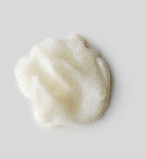 A soft, fluffy white cloud-like object on a light background, resembling cotton or foam.