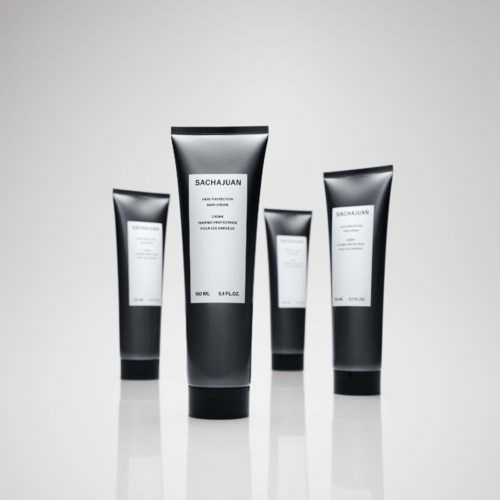 Four tubes of skincare products labeled 'SACHAJUAN' stand on a reflective surface with a plain background.