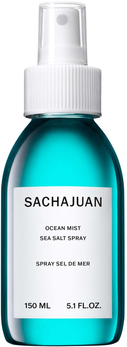 A small blue spray bottle labeled 'SACHAJUAN Ocean Mist Sea Salt Spray' with a white spray nozzle.