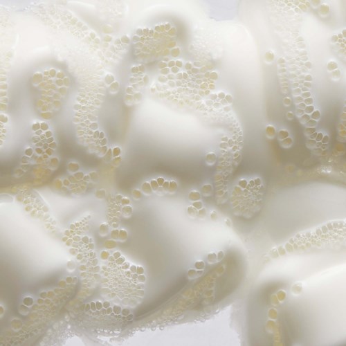 Närbild av skum med många små bubblor, skapar en bubblig och skummig yta.