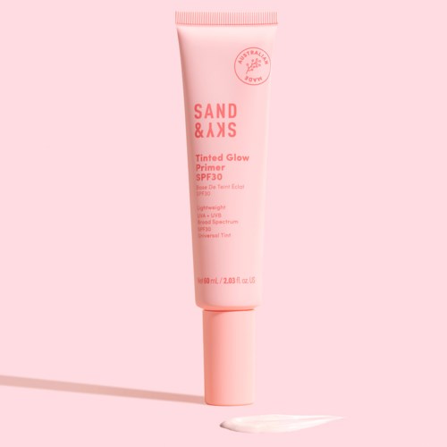 En rosa tub med tinted glow-primer med SPF 30, visar varumärket och produktdetaljer, samt en liten mängd produkt.