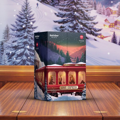 En festlig eske med en rød togmerke Love Express, plassert foran en vinterscene med snø, furutrær og fjell.