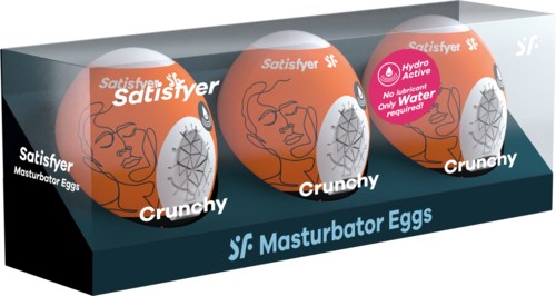 Drie oranje eieren met illustraties en tekst, gelabeld als masturbatie-eieren in een zwarte displaydoos.