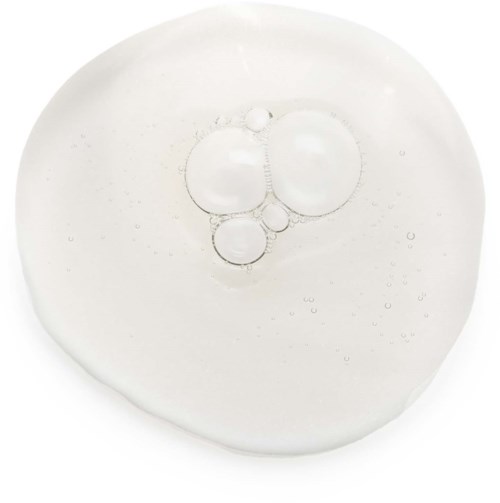 Doorzichtige vloeistof met belletjes erin, op een witte achtergrond, lijkt op een druppel olie of water.