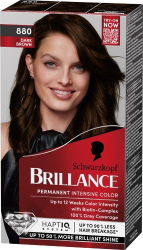En kvinde med langt brunt hår smiler og holder en boks med Schwarzkopf Brillance hårfarve.