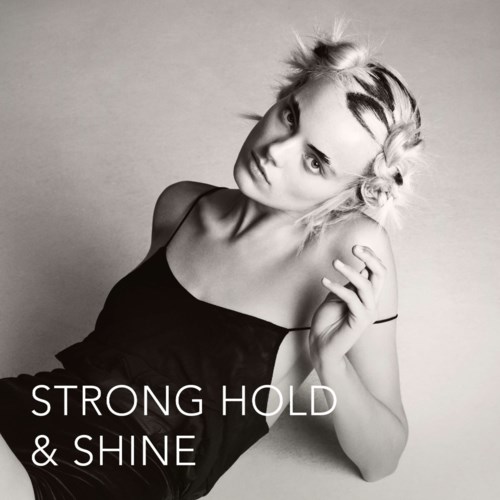 En kvinne med flettet hår i en svart kjole. Teksten sier "Strong Hold & Shine." Svart-hvitt bilde.