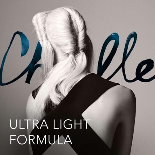 En kvinna med platinahår som vänder sig bort, med orden "Ultra Light Formula" på en enkel bakgrund.