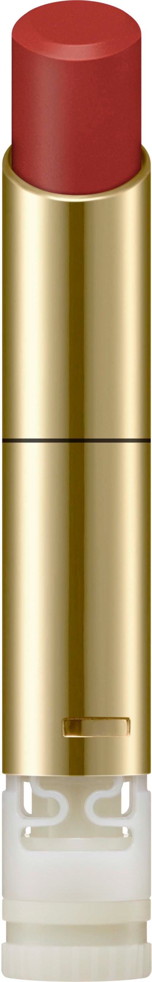 Ein Lippenstift mit roter Farbe, goldenem Gehäuse und klarem Boden. Es steht aufrecht vor einem schwarzen Hintergrund.