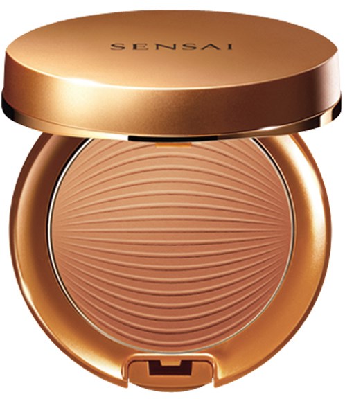 En rund, gyllene kompakt med en texturerad puder inuti och märket "SENSAI" på locket.