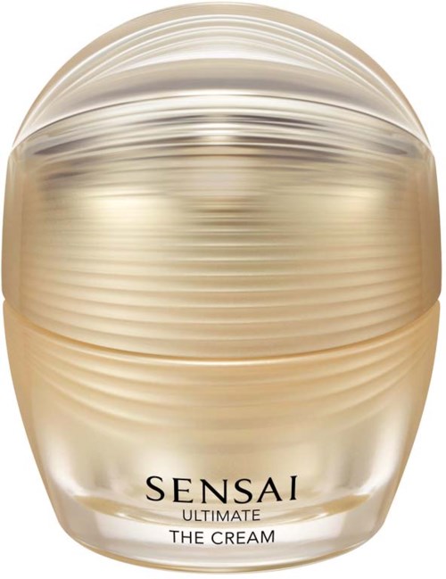 En krukke af Sensai Ultimate The Cream, guldfarvet med horisontale linjer, ser luksuriøs og elegant ud.