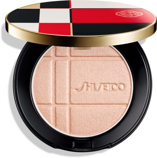 Geöffneter Kompakt mit peachfarbener gepresster Puder, geprägt mit dem Markennamen Shiseido und geometrischen Linien.