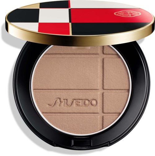 Eine Kompakt mit beigeurnem Puder und dem eingedrückten Markennamen Shiseido, in einem schwarzen Gehäuse mit farbigem Deckel.