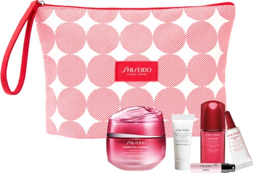 A pink and white patterned pouch with a red handle, containing skincare products and a small white tube.