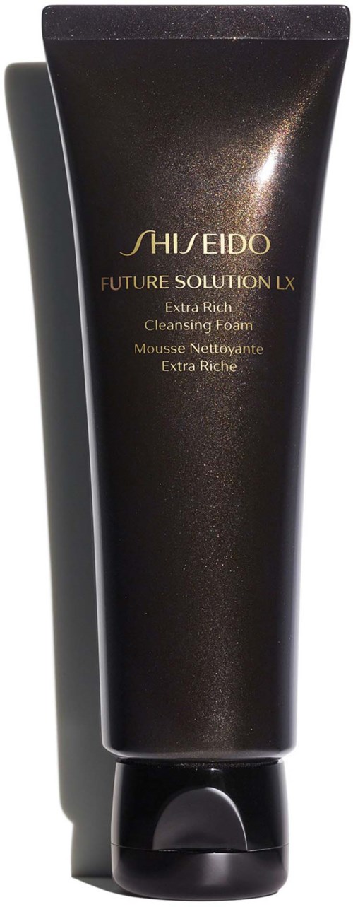 Een donkere tube met de tekst 'Shiseido Future Solution LX Extra Rich Cleansing Foam' staat rechtop met een schaduw ernaast.