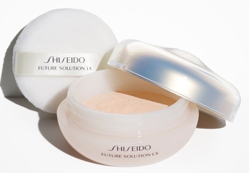 En krukke af Shiseido Future Solution LX-creme uden låg, og en pudderpude. Krukken er hvid med sølvdetaljer.