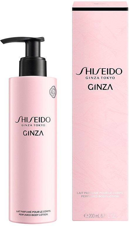 Lyserosa flaske med svart pumpe, ved siden av en rosa eske. Begge har svart og sølv tekst. Produktet er bodylotion.