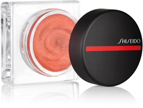 En krukke med oransje kosmetisk krem med svart lokk som har en rød strek og merket Shiseido.