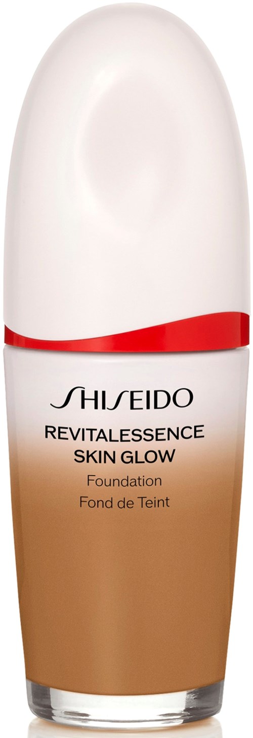 En flaske av Shiseido Revitalessance Skin Glow foundation med hvit topp, rød bånd og beige bunn.