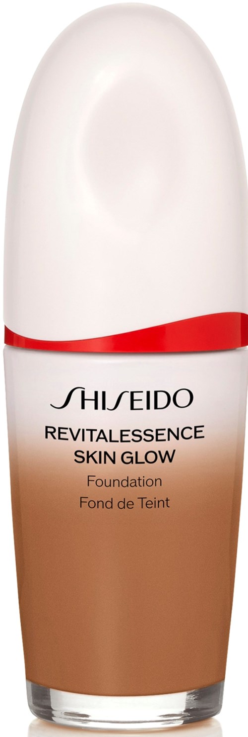 En flaske av Shiseido Revitalessence Skin Glow Foundation med hvit og beige design og rød linje.
