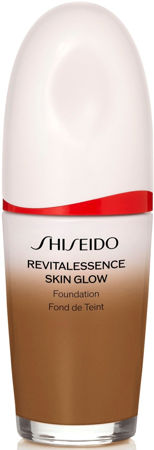 En foundation flaske fra Shiseido, med en gradient brun bunn, hvitt topp og rødAccent-bånd.