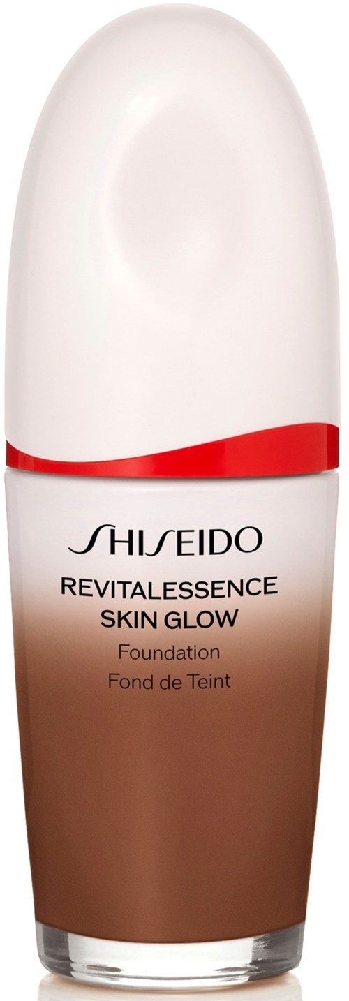 En flaske med Shiseido Revitalessence Skin Glow foundation med hvit kork og brunt innhold.