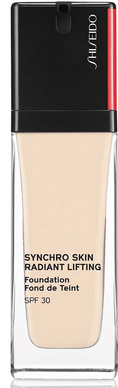 En foundationflaska med svarta, röda och klara delar. Den är märkt 'Synchro Skin Radiant Lifting' med SPF 30.