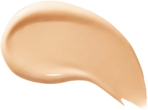 Ett beige foundationspridning med en slät, krämig konsistens på en vit bakgrund.