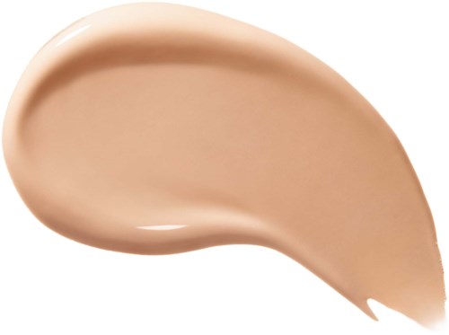 En beigefärgad kräm eller lotion spridd i en tårform. Den ser slät och tjock ut.