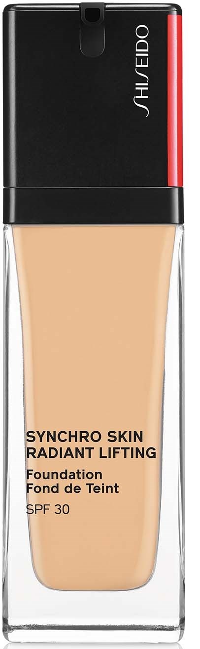 En foundationflaska märkt 'Synchro Skin Radiant Lifting' med SPF 30, i en klar behållare med svart och röd lock.