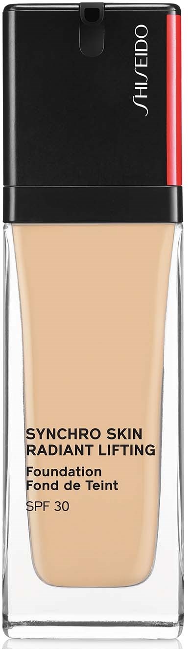 En foundationflaska med svart och röd topp, beige flytande och Shiseido-loggan högst upp.