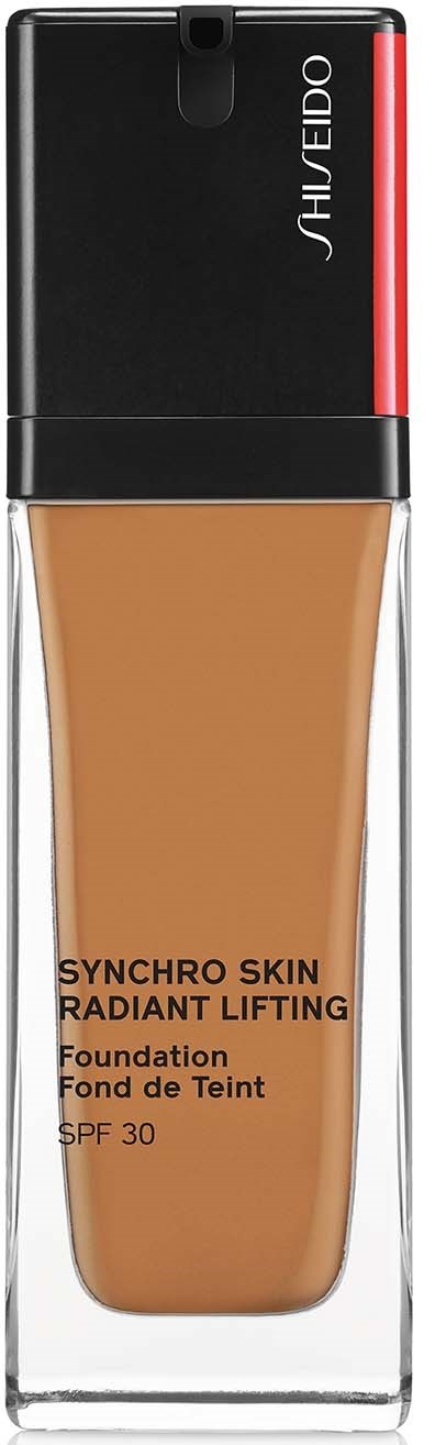 En foundationflaska med svart och röd topp, tydligt glas som visar beige foundation, och text om att undvika åldrande.