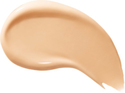 En beige farget krem eller foundation spredt i en buet form på en hvit bakgrunn.