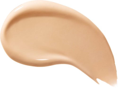 En beige vätska eller kräm i en teardropsform, slät och glansig.