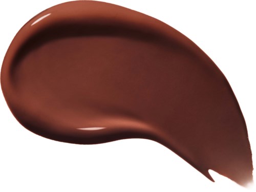 En brun, buet klatt av kremaktig substans, muligens sjokolade eller sminkeprodukt, på hvit bakgrunn.