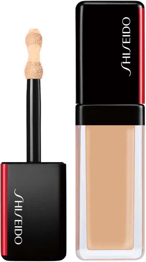 En Shiseido flytende foundationflaske med åpen applikatorbørste. Flasken er svart med røde detaljer og hvit tekst.