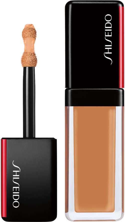 En flytende foundationflaske og påføringsverktøy med svart lokk og rød stripe, merket Shiseido.