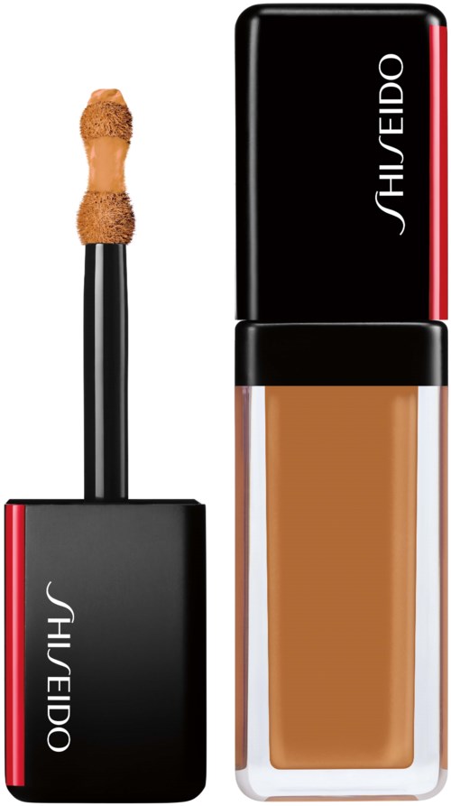 En makeupfundamentflaske og påføringsbørste med svart og rødt design, merket 'Shiseido'.