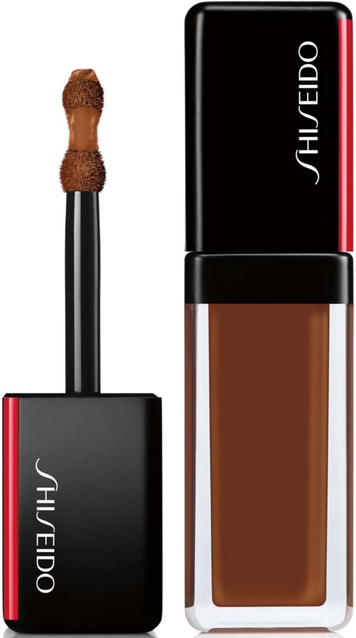 En Shiseido-makeupprodukt, med en applikator och en flaska med brunt flytande foundation.
