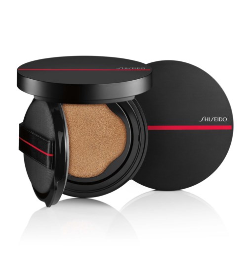 En rund svart kompakt med svamp inuti och ett lock med röda detaljer, märkt Shiseido.