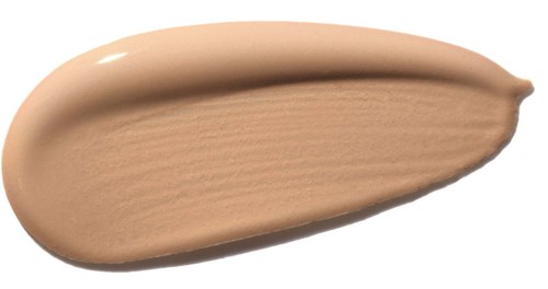 Ett beige flytande foundationsprov med en slät yta på svart bakgrund.