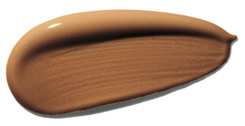 Ein Strich aus beigen-brauner Make-up-Grundlage oder Creme, geformt wie ein längliches Oval mit spitzem Ende.